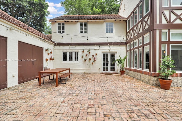 rear view of house featuring french doors, a patio, and stucco siding