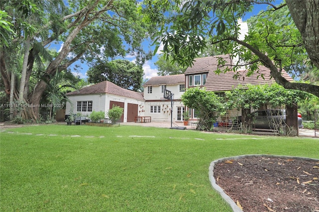 rear view of house with a patio, a lawn, and an outdoor structure