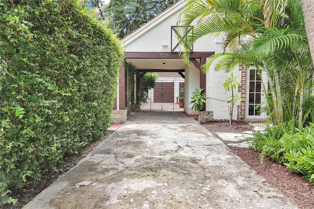 exterior space with driveway, a gate, and a carport