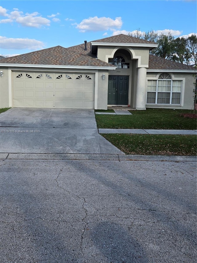 view of front facade with concrete driveway, an attached garage, and stucco siding