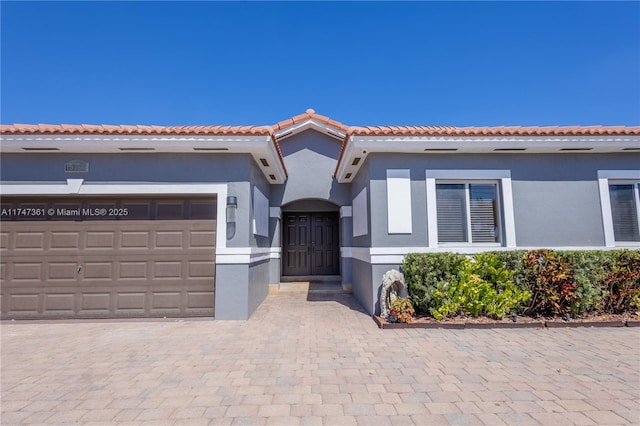 15333 SW 184th St, Miami, FL 33187 - mediterranean / spanish-style house with decorative driveway, an attached garage, a tile roof, and stucco siding