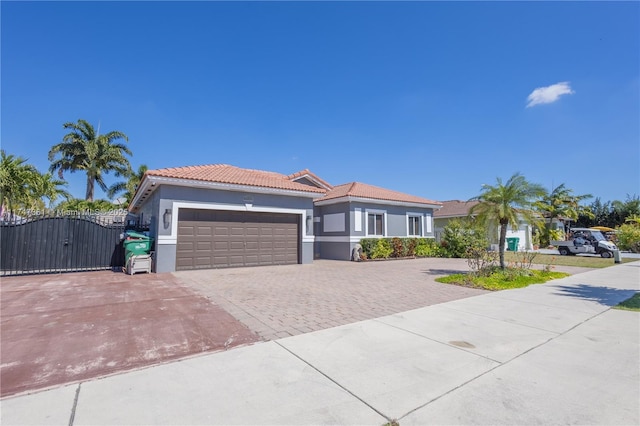 15333 SW 184th St, Miami, FL 33187 - mediterranean / spanish house featuring an attached garage, a tile roof, decorative driveway, a gate, and stucco siding