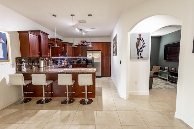 15333 SW 184th St, Miami, FL 33187 - kitchen featuring light tile patterned floors, a peninsula, dark brown cabinets, appliances with stainless steel finishes, and tasteful backsplash
