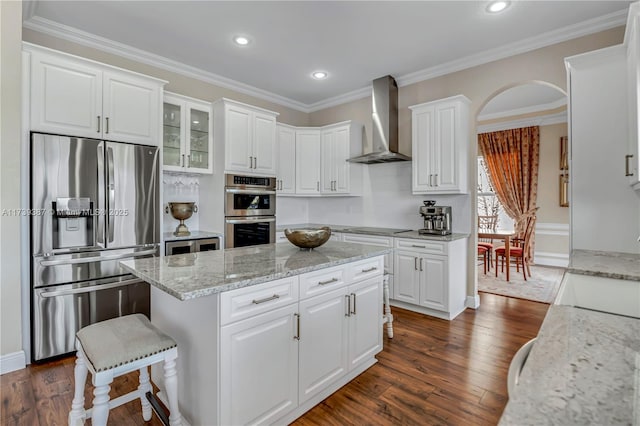 19239 SW 54th St, Miramar, FL 33029 - kitchen with stainless steel appliances, wall chimney exhaust hood, a kitchen island, dark wood-type flooring, and white cabinetry