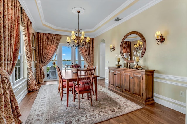 19239 SW 54th St, Miramar, FL 33029 - dining space featuring a chandelier, wood finished floors, ornamental molding, a water view, and arched walkways