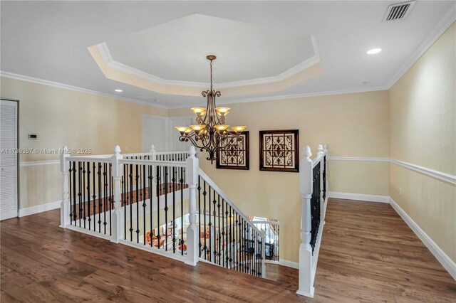 bedroom featuring a tray ceiling, light wood-style floors, and access to exterior