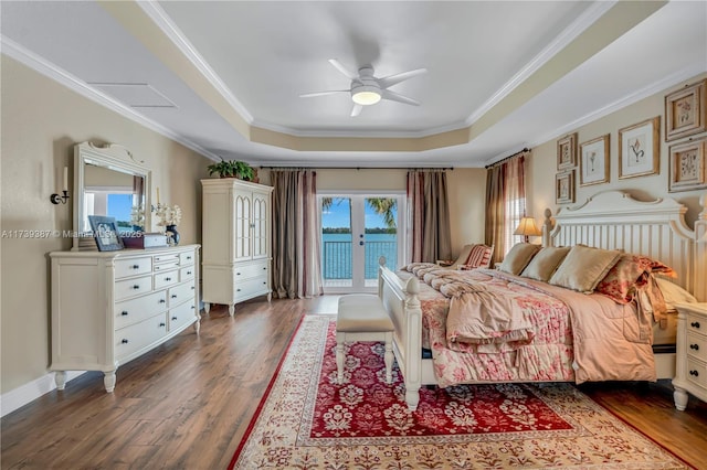 bedroom featuring a tray ceiling, dark wood-style floors, crown molding, and access to outside