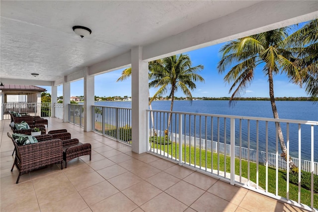 view of patio with a balcony and a water view