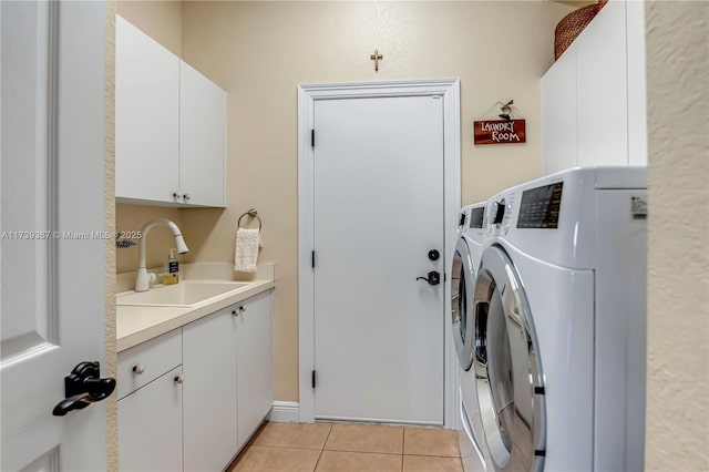 laundry area featuring light tile patterned floors, cabinet space, independent washer and dryer, and a sink