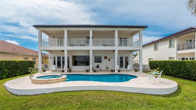 back of house with a pool with connected hot tub, ceiling fan, french doors, a balcony, and a patio area