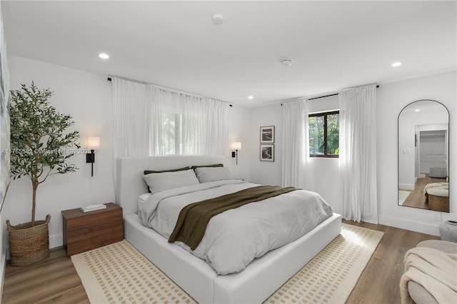 bedroom with recessed lighting and wood finished floors