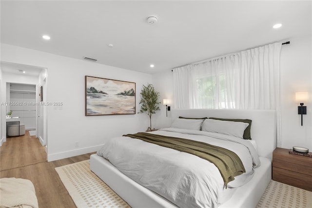 bedroom with light wood-style floors, recessed lighting, and baseboards