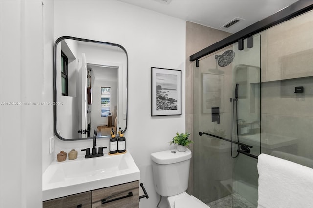 bathroom with a stall shower, visible vents, vanity, and toilet