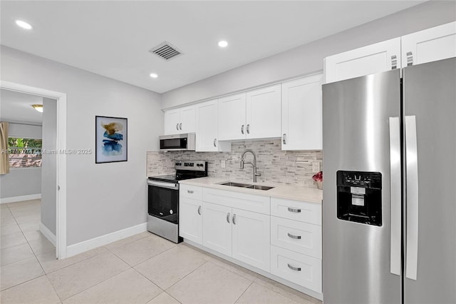 kitchen featuring stainless steel appliances, light countertops, visible vents, decorative backsplash, and a sink