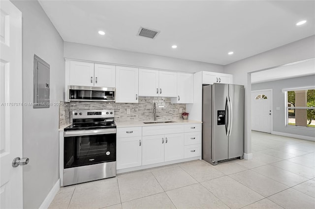 5248 N Andrews Ave, Oakland Park, FL 33309 - kitchen featuring stainless steel appliances, light countertops, backsplash, white cabinetry, and a sink