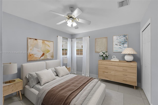 bedroom featuring light tile patterned floors, ceiling fan, and visible vents