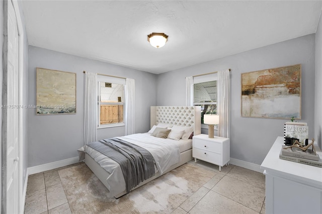 bedroom featuring light tile patterned flooring and baseboards