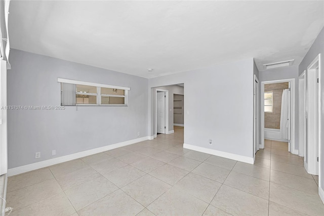 spare room with light tile patterned floors, visible vents, and baseboards