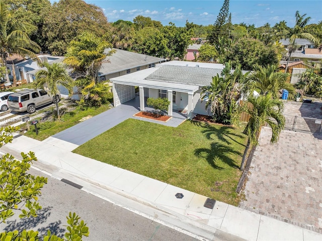 view of front of home with an attached carport, driveway, a front lawn, and fence