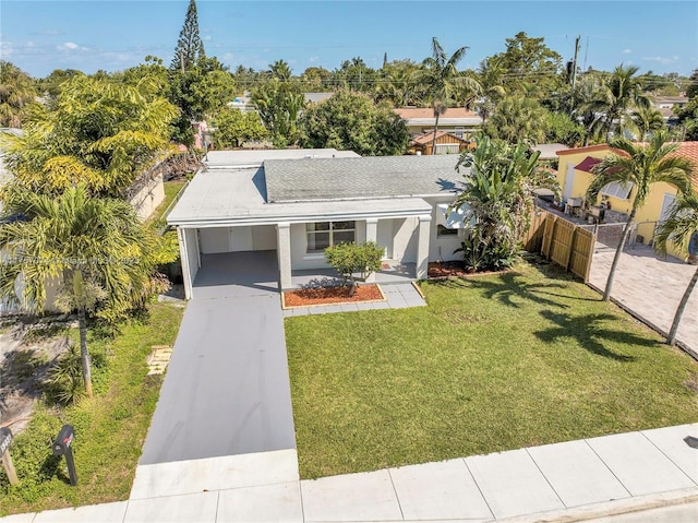 5248 N Andrews Ave, Oakland Park, FL 33309 - view of front of house with fence, concrete driveway, stucco siding, a carport, and a front lawn
