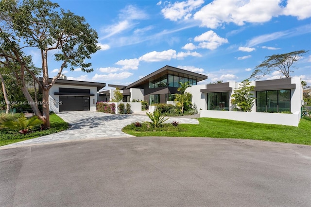 6991 SW 91st St, Pinecrest, FL 33156 - contemporary house with stucco siding, decorative driveway, an attached garage, and a front yard