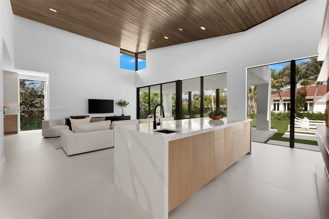 6991 SW 91st St, Pinecrest, FL 33156 - kitchen featuring modern cabinets, light brown cabinetry, light stone countertops, wood ceiling, and healthy amount of natural light