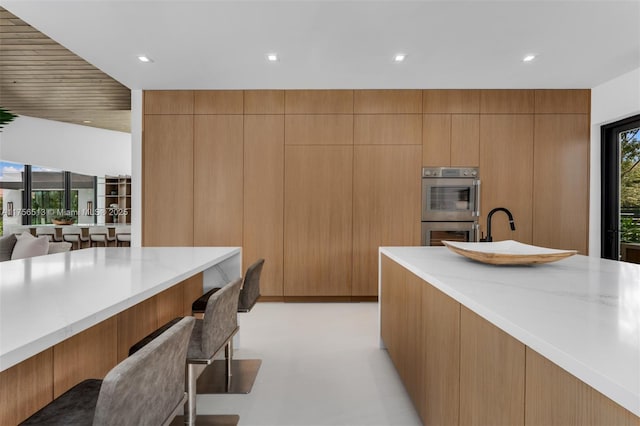 6991 SW 91st St, Pinecrest, FL 33156 - kitchen featuring double oven, a breakfast bar, modern cabinets, recessed lighting, and open floor plan