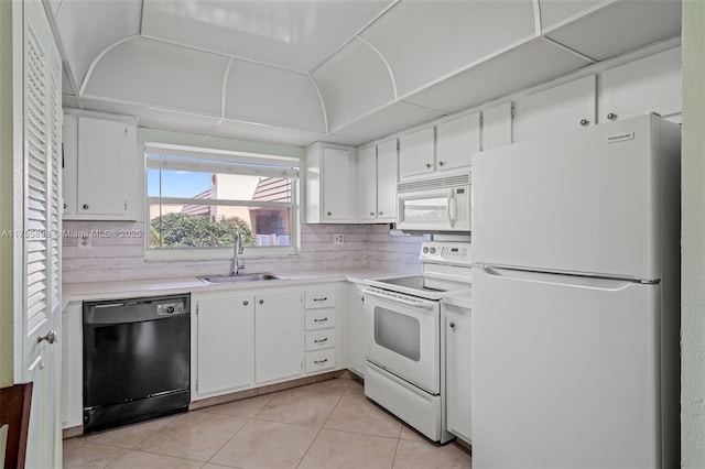 kitchen featuring light tile patterned floors, light countertops, white cabinets, a sink, and white appliances