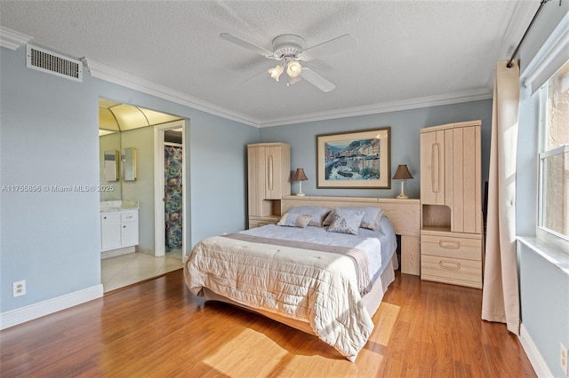 bedroom featuring ornamental molding, visible vents, a textured ceiling, and wood finished floors