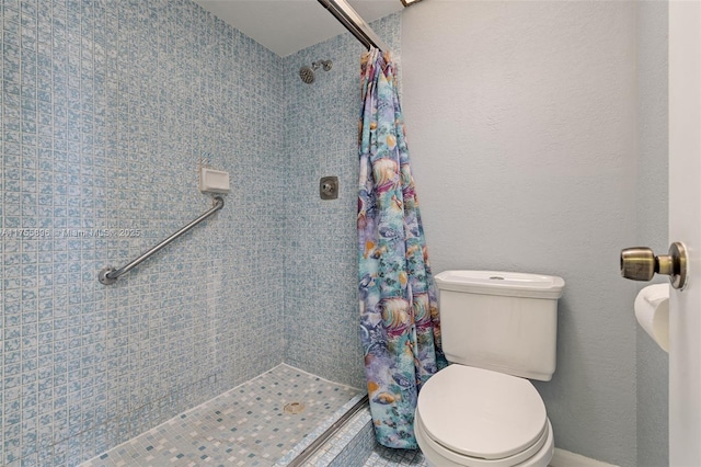 full bath with a textured wall, a stall shower, and toilet