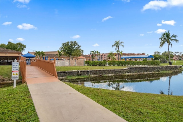 view of home's community featuring a water view and a yard