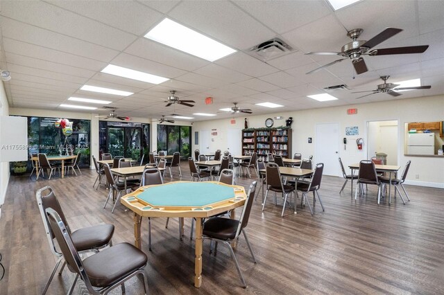 dining space featuring visible vents, a drop ceiling, and wood finished floors