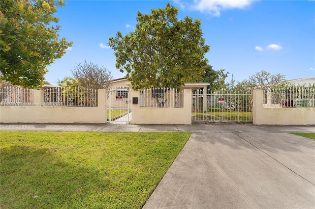 view of front facade featuring a fenced front yard, a front yard, a gate, and stucco siding