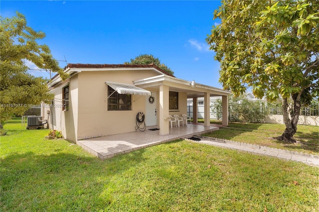 exterior space featuring central air condition unit, a front yard, fence, and stucco siding