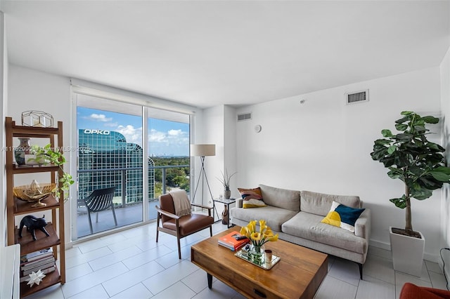 living area featuring light tile patterned floors, expansive windows, and visible vents