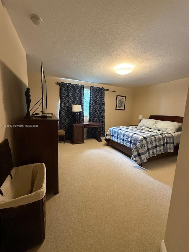 bedroom featuring light carpet and a textured ceiling