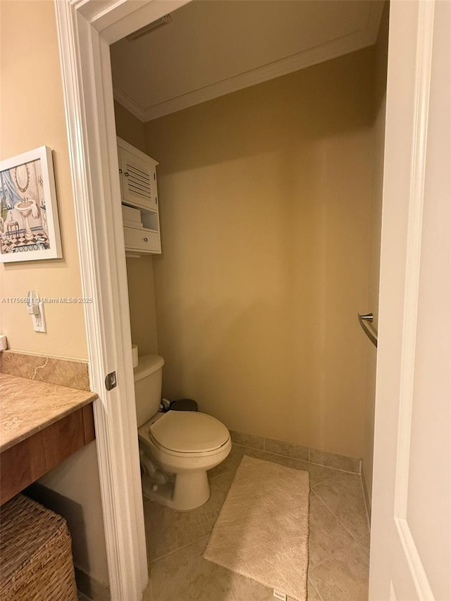 bathroom featuring baseboards, toilet, ornamental molding, tile patterned floors, and vanity