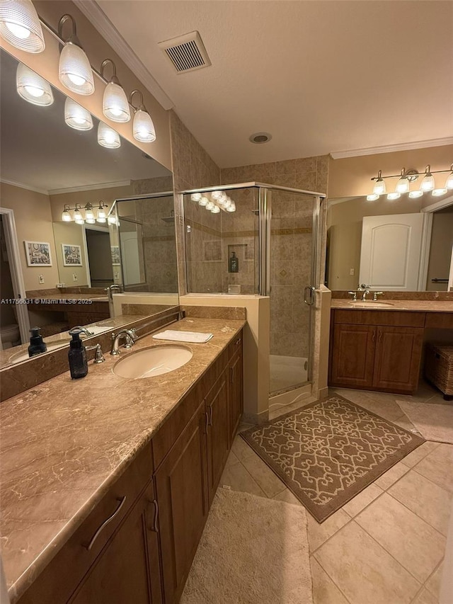 bathroom with ornamental molding, a stall shower, a sink, and visible vents