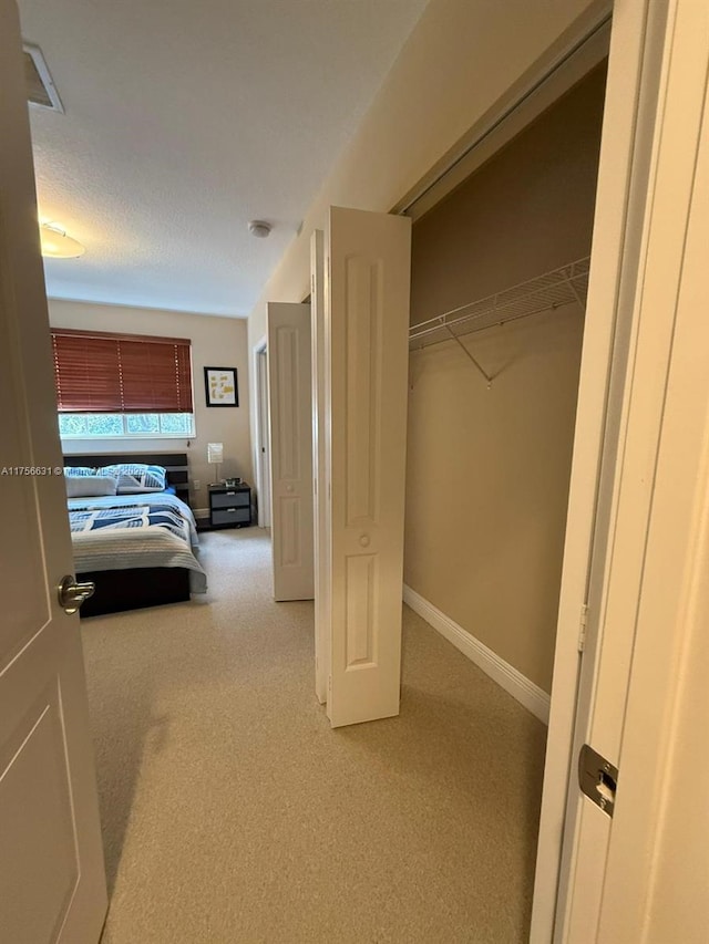 unfurnished bedroom featuring carpet floors, baseboards, and a closet