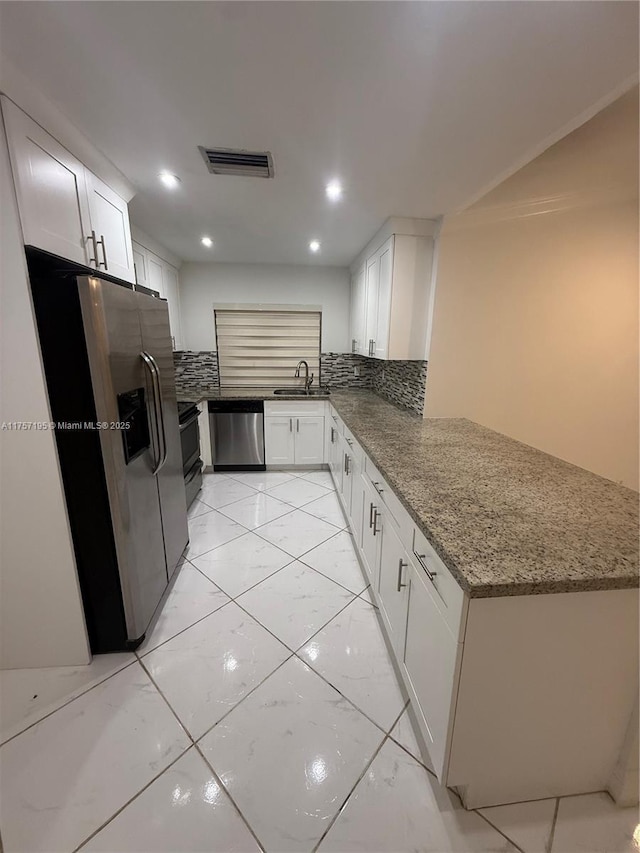 kitchen with tasteful backsplash, visible vents, appliances with stainless steel finishes, marble finish floor, and a sink