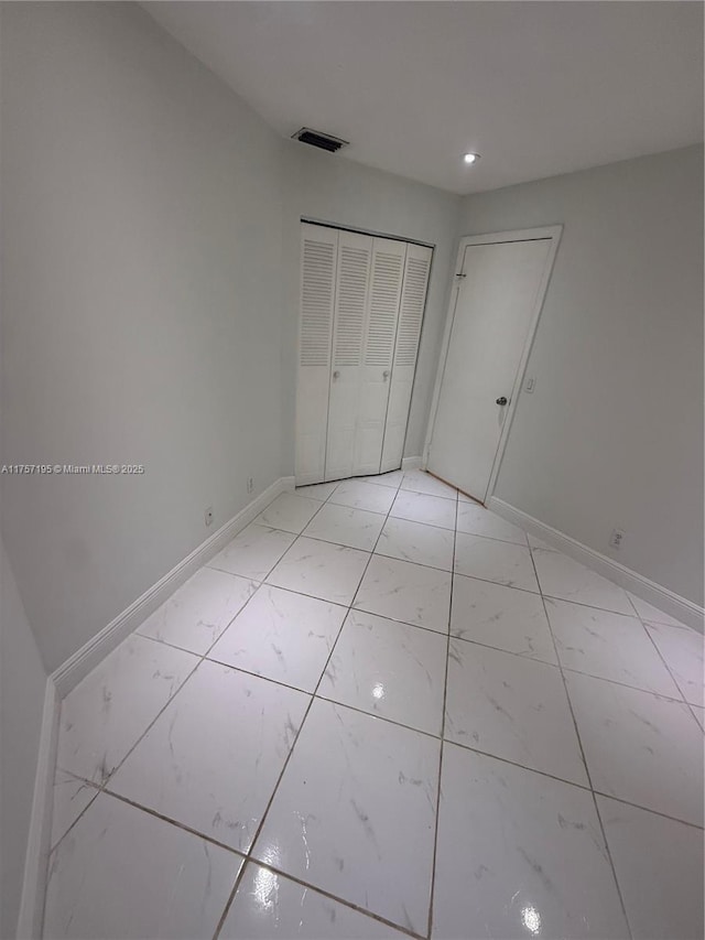 unfurnished bedroom featuring recessed lighting, visible vents, baseboards, marble finish floor, and a closet