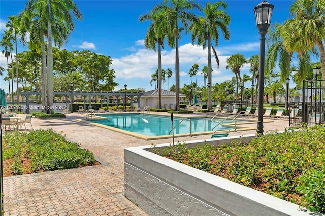 community pool with a patio and fence