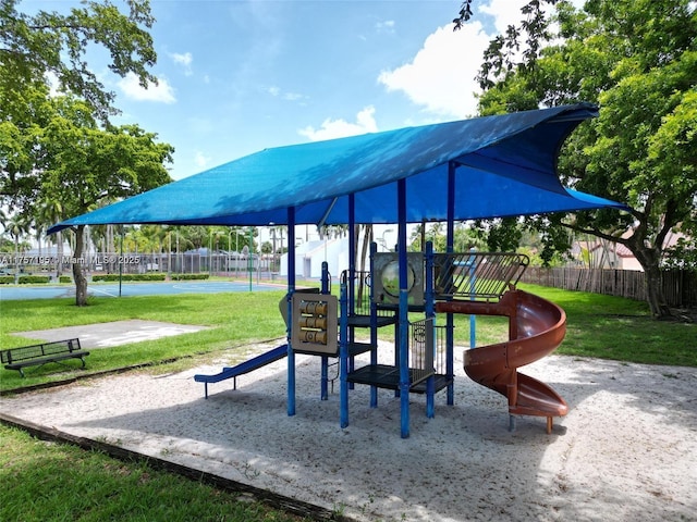 communal playground featuring fence and a yard