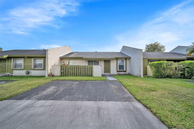 view of front of property featuring fence and a front lawn