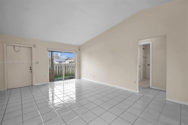 unfurnished room with lofted ceiling, light tile patterned floors, and baseboards