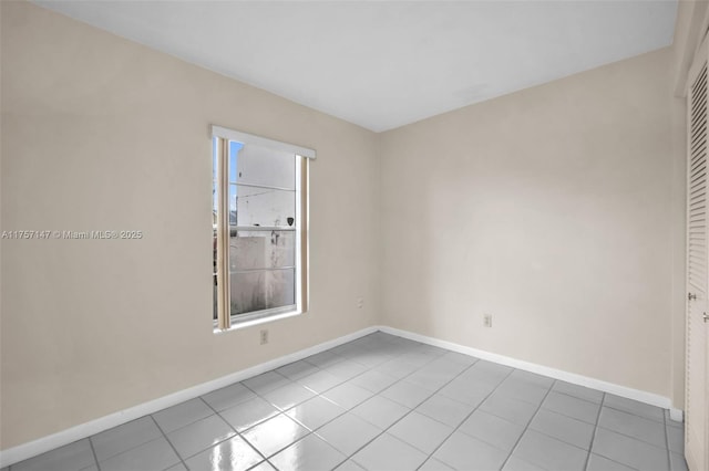 spare room featuring baseboards and tile patterned floors