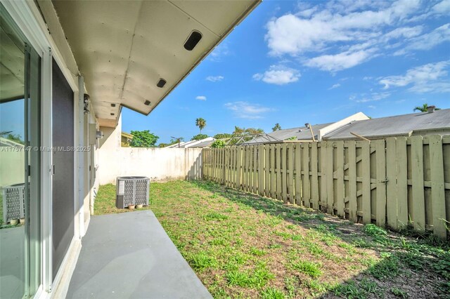 view of yard with a patio, central AC unit, and a fenced backyard