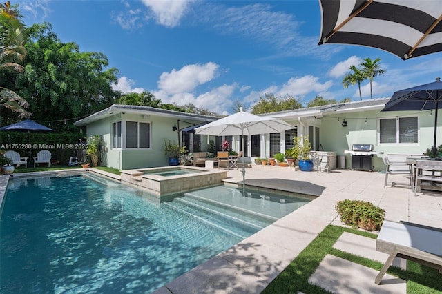 back of property featuring a patio, a pool with connected hot tub, and stucco siding