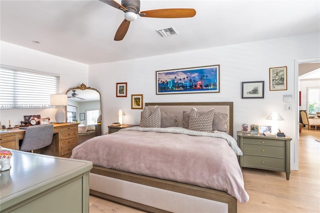 bedroom featuring a ceiling fan, light wood-style flooring, and visible vents
