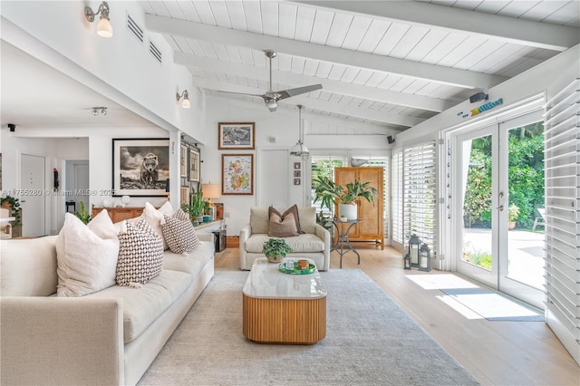 living area featuring light wood finished floors, a ceiling fan, vaulted ceiling with beams, visible vents, and wood ceiling